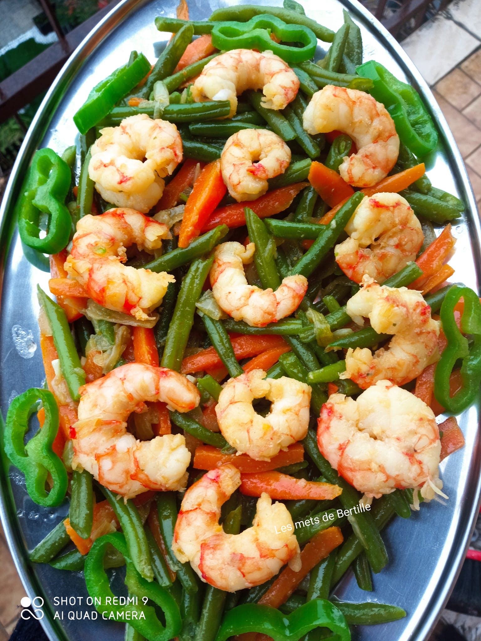 Entrée chaude aux crevettes sautées à l’ail, haricots verts et carottes.