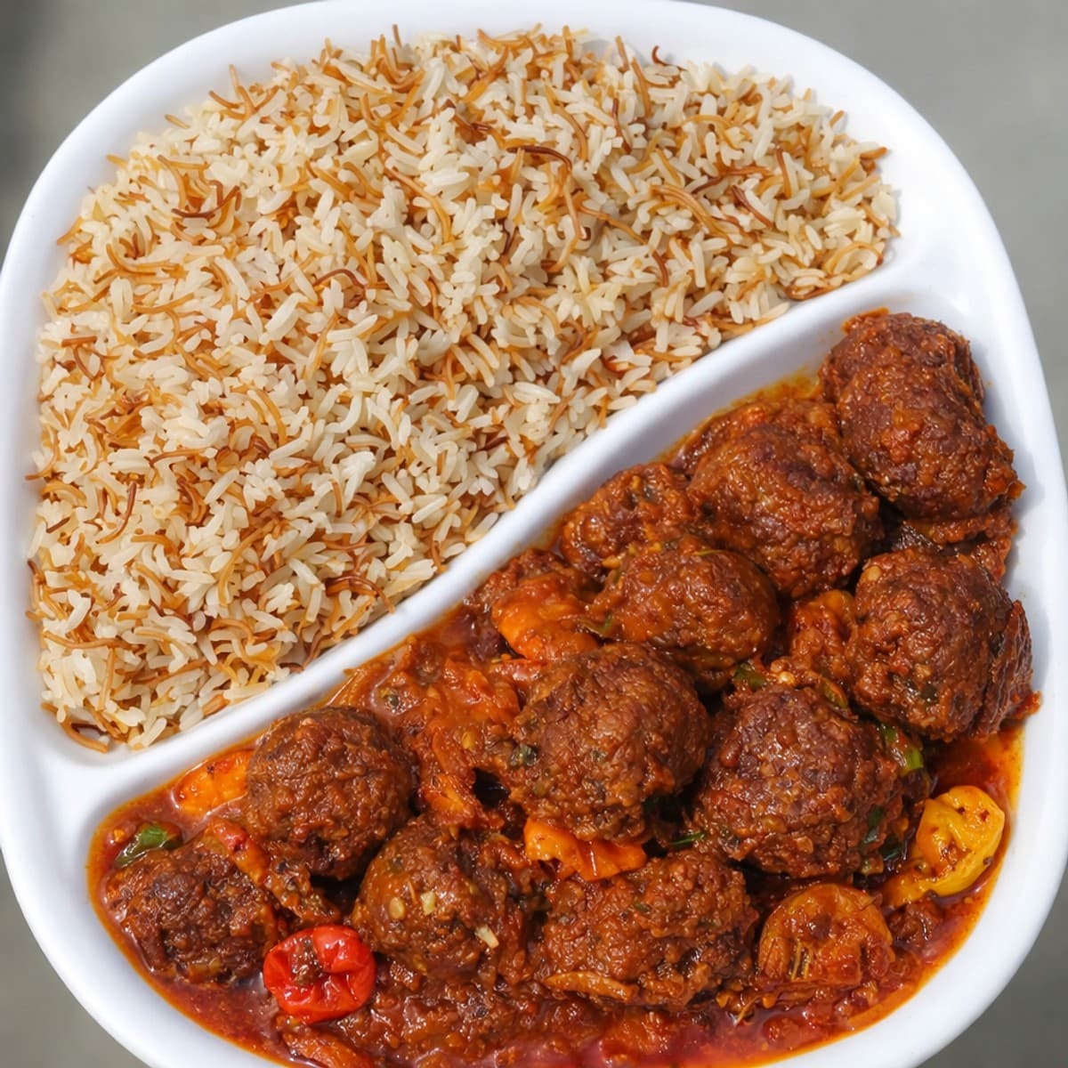 Riz vermicelles et sa sauce tomate boulettes de poisson et crevettes.