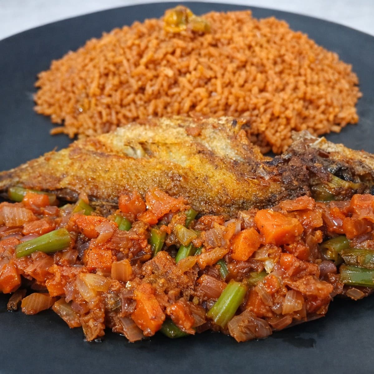 Riz jollof et son poisson frit avec légumes